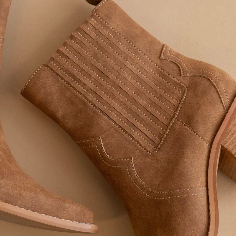 Brown suede ankle boot on a beige background