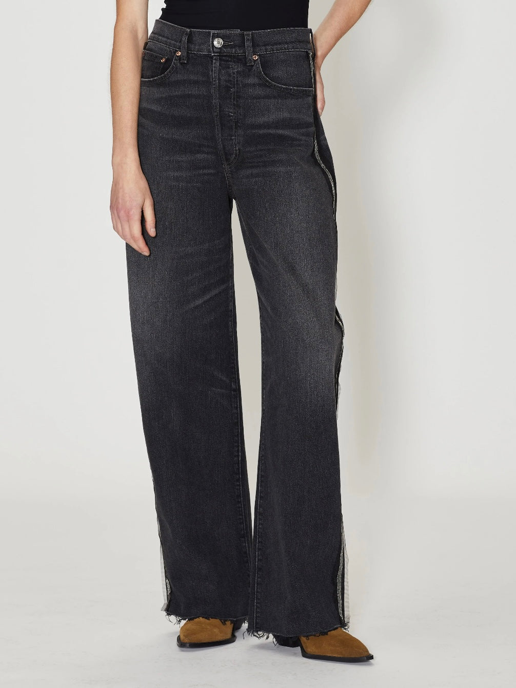A pair of vintage charcoal striped denim jeans with high-waist cut, button fly, and metal beaded trim on the side seams, worn by a model.