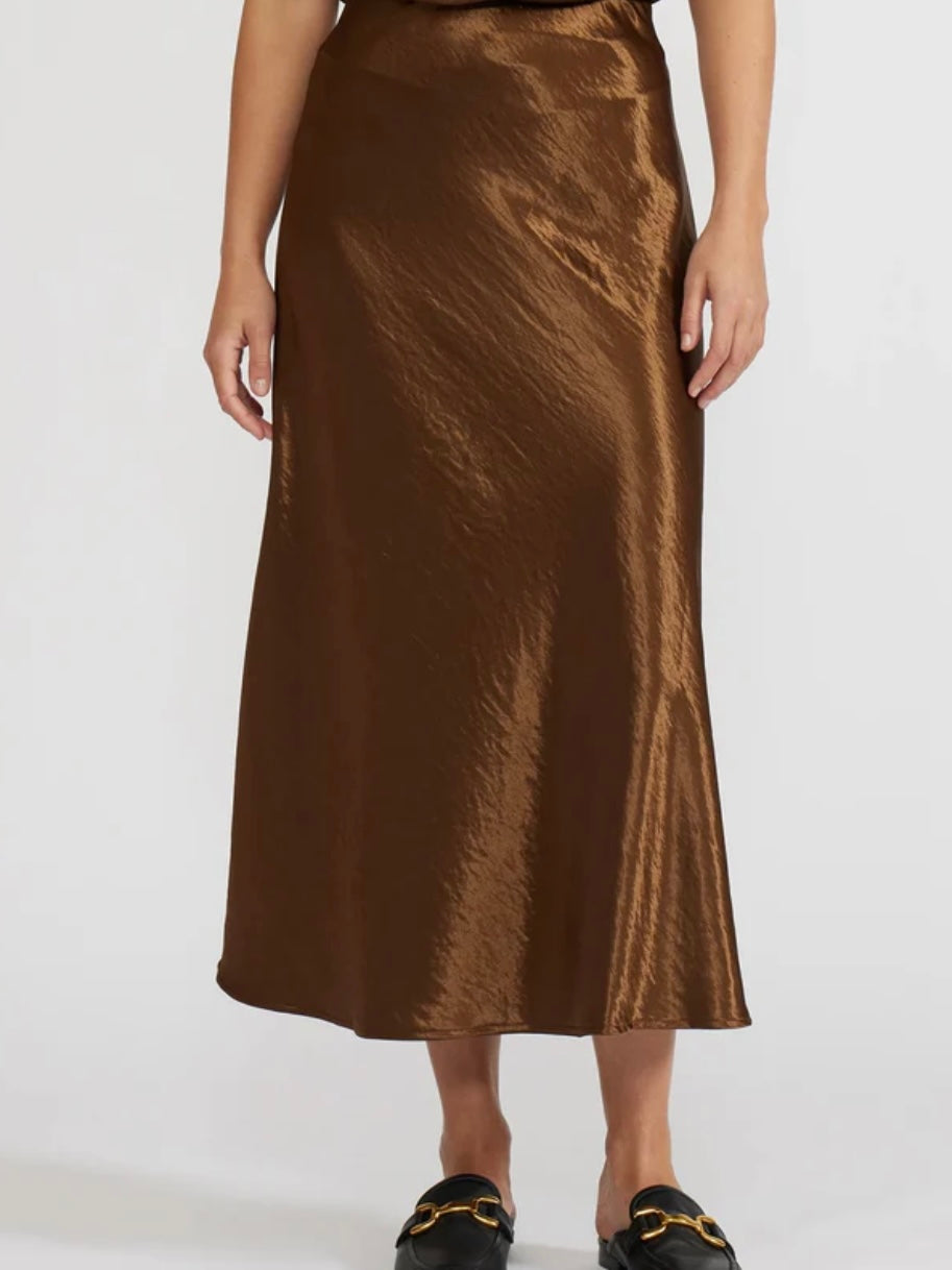 Brown satin skirt worn by a person on a white background