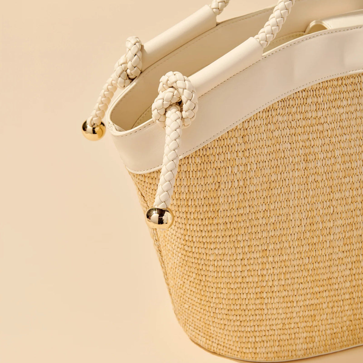 Woven handbag with rope handles on a beige background