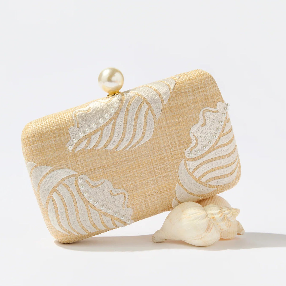 Yellow clutch bag with white floral patterns on a light gray background