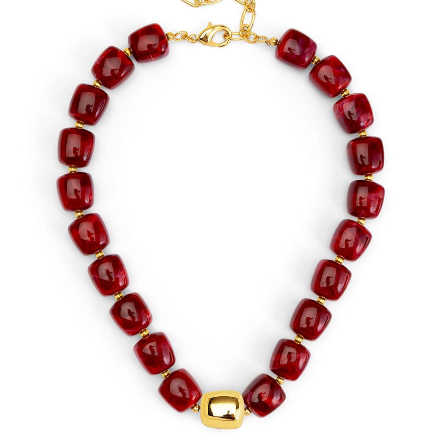 Necklace with red beads and gold clasp on a white background