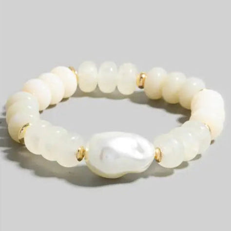 Pearl bracelet with gold accents on a light gray background