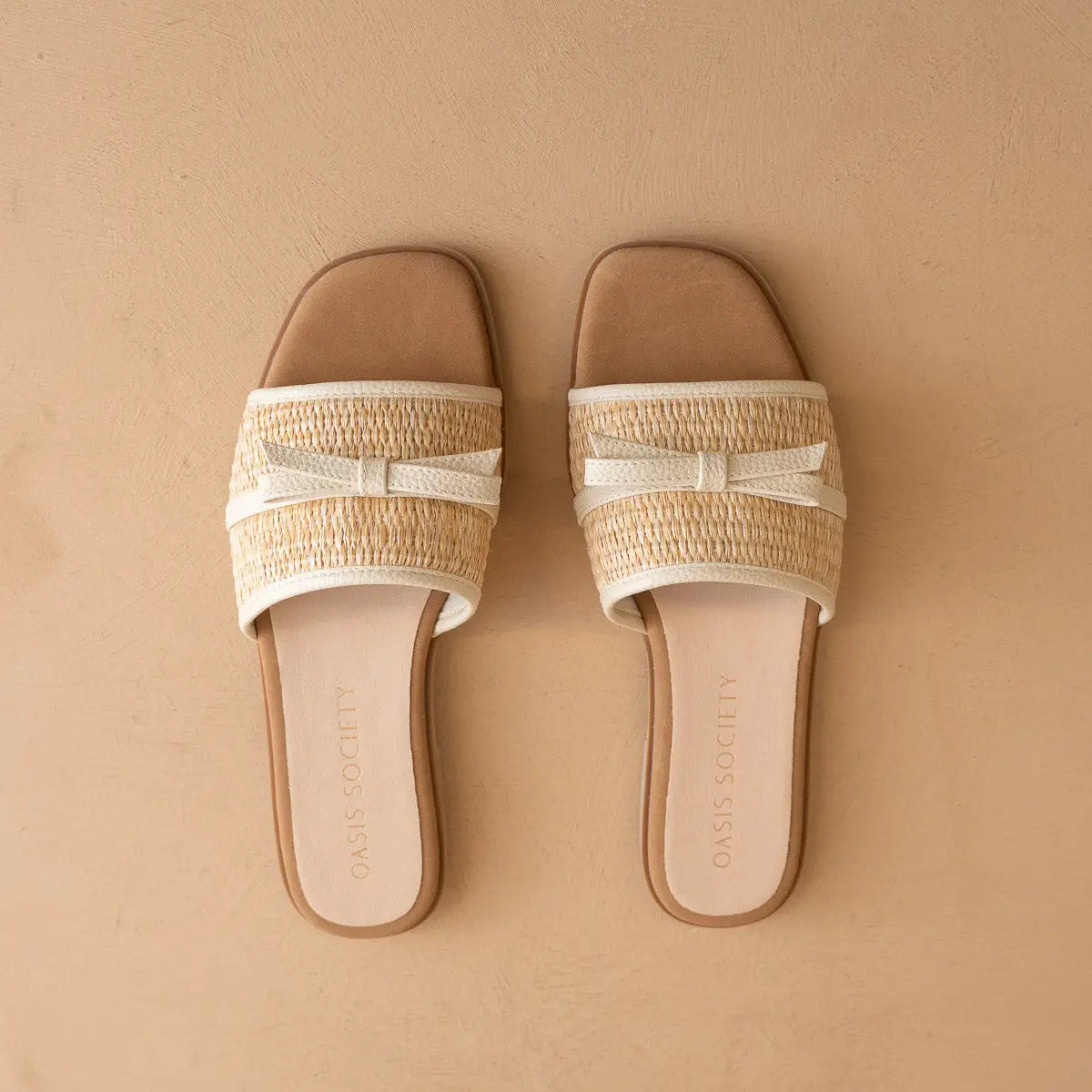 Pair of sandals with woven straps on a beige background