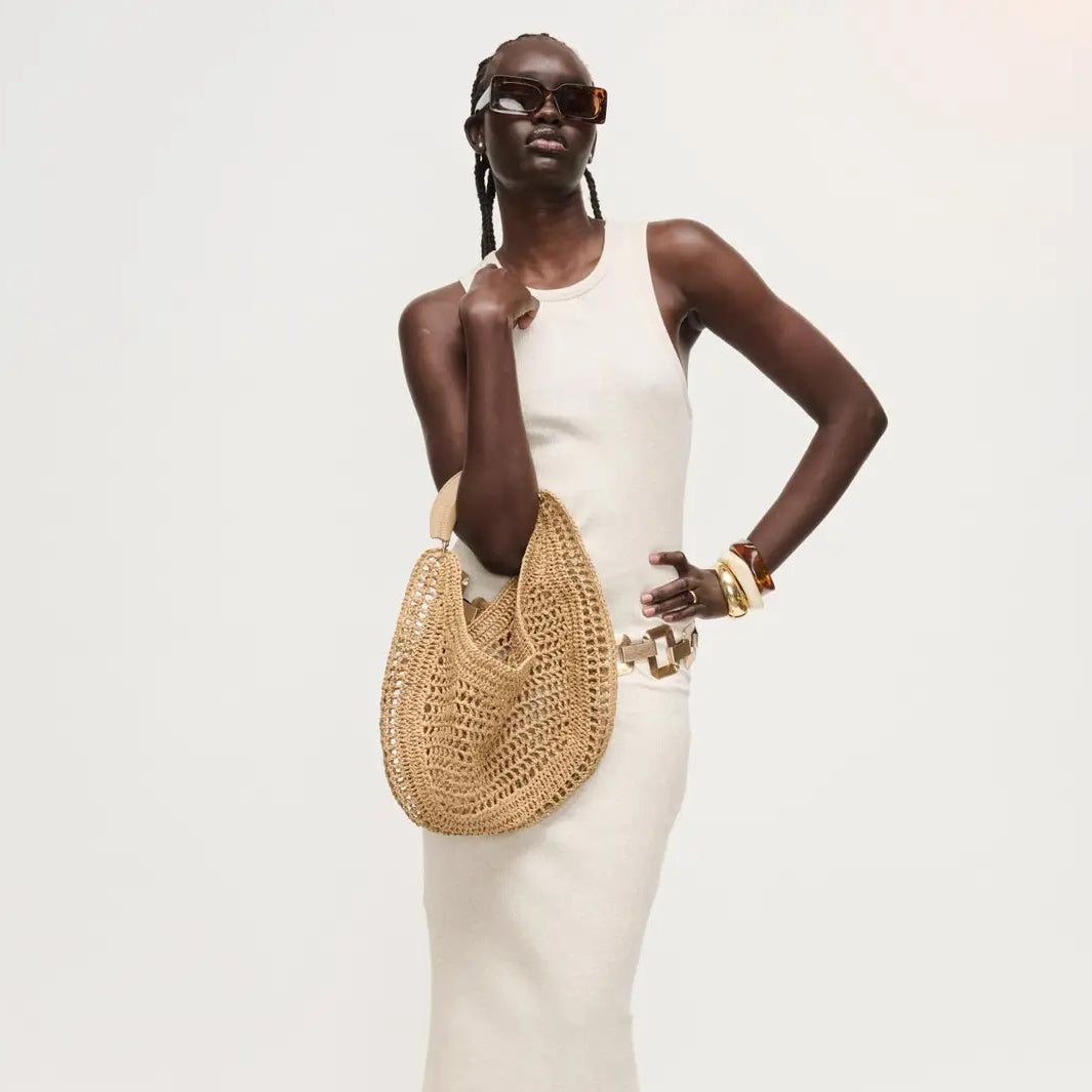 Woman holding a woven handbag against a white background