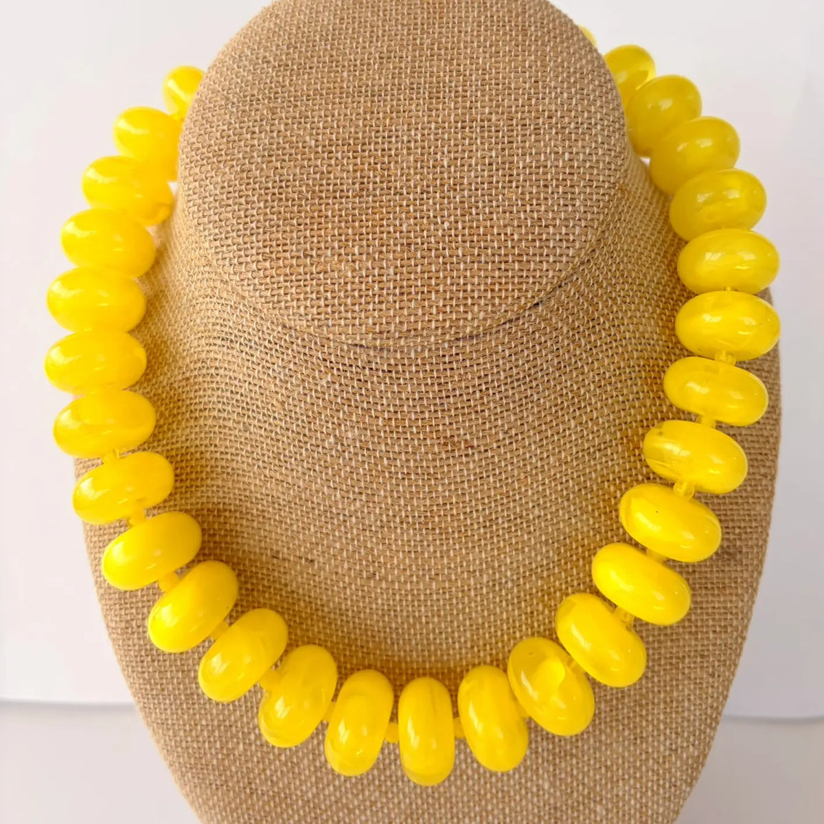 Brown straw hat with yellow bead embellishments on a mannequin head.