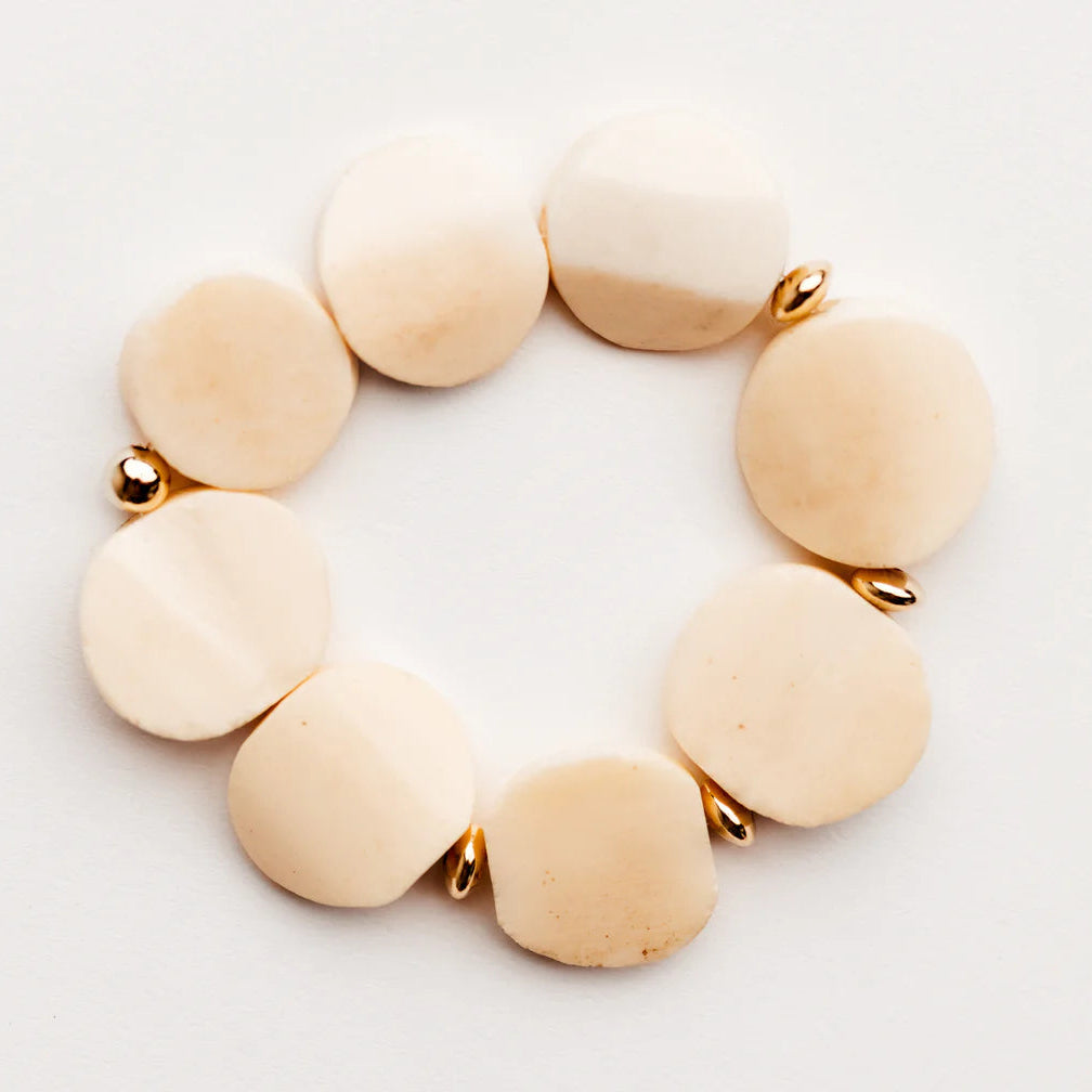 Beige beaded bracelet on a light gray background