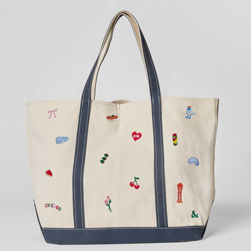 Tote bag with embroidered designs on a light gray background