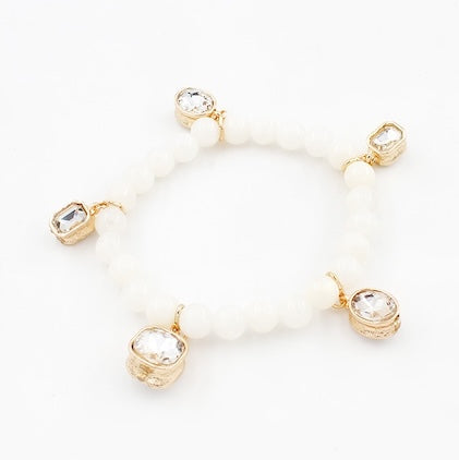 Gold bracelet with clear gemstones on a white background