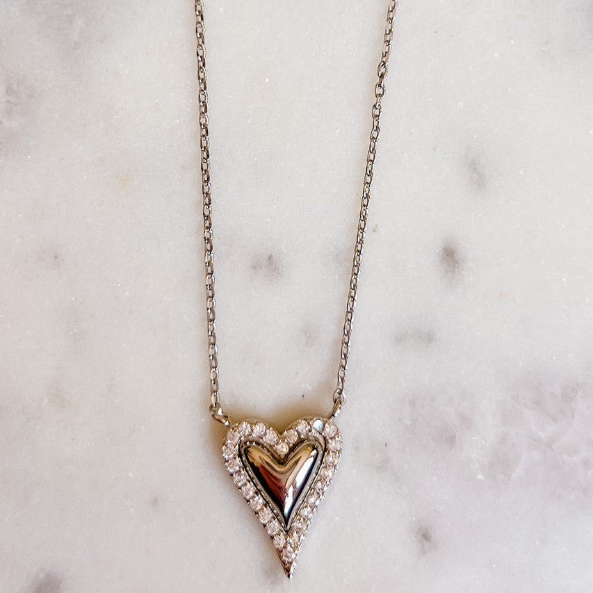 Necklace with a heart-shaped pendant on a marble surface