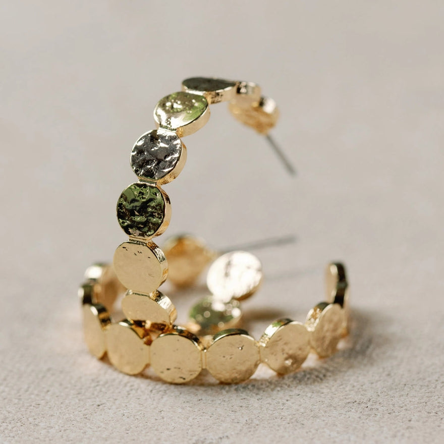 Gold ring with green gemstone on a light gray background