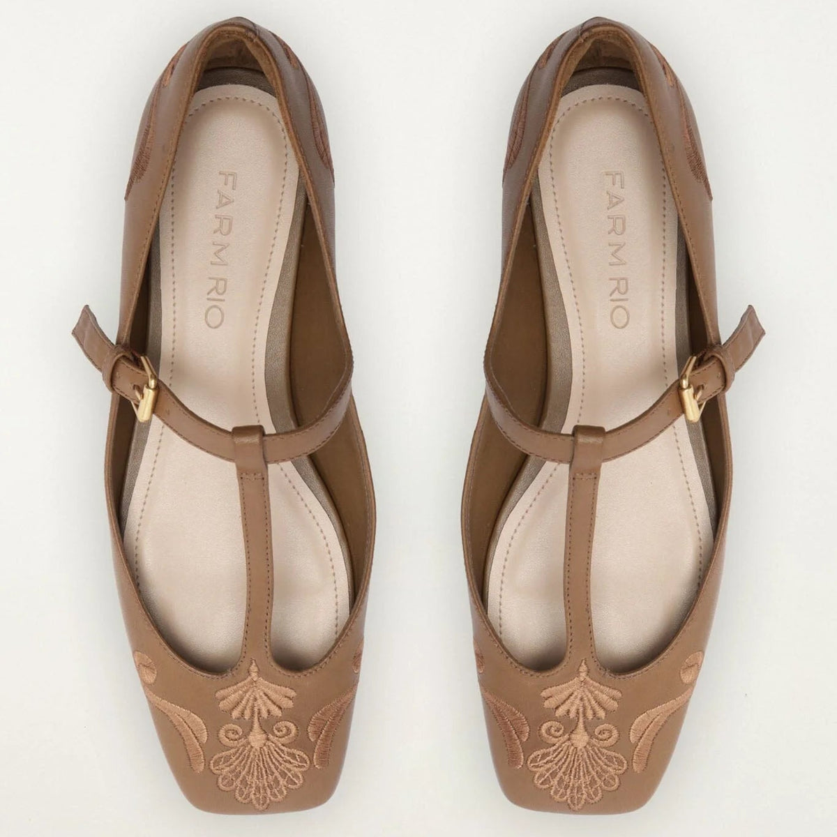 A pair of Farnório brown leather T-strap ballet flats with embroidered floral detailing on the toes, shown from a top-down view on a white background.