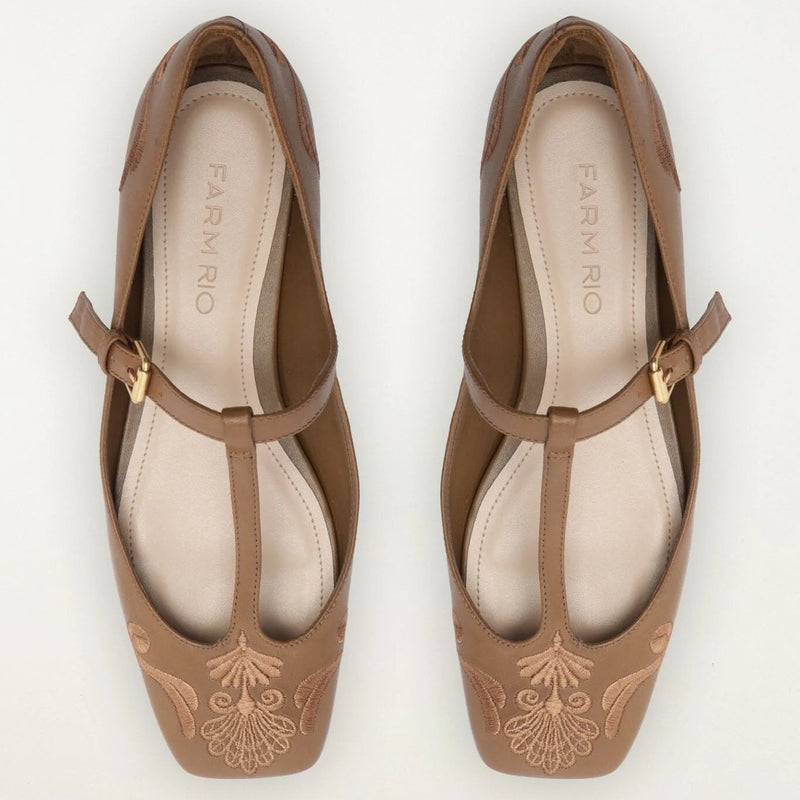 A pair of Farnório brown leather T-strap ballet flats with embroidered floral detailing on the toes, shown from a top-down view on a white background.